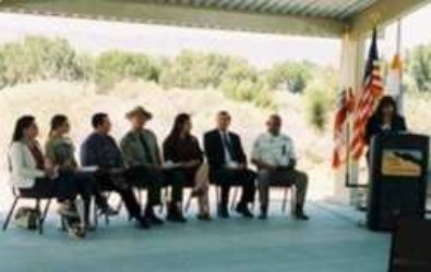A collection of speakers sit on stage at the endangered species day conference
